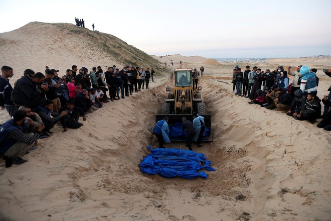 Palestinci pri pokopu svojih bližnjih. FOTO: Ibrahim Abu Mustafa/Reuters