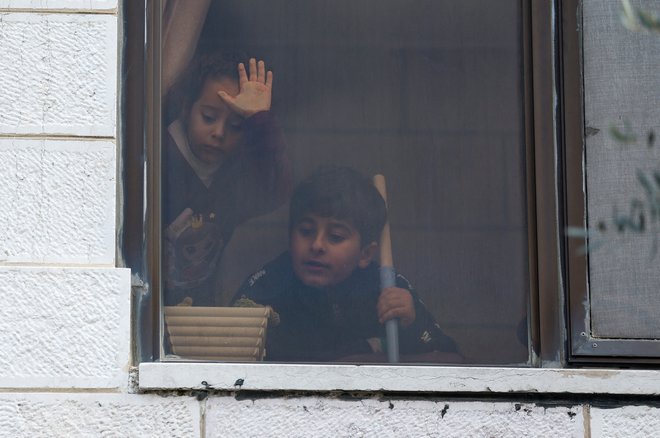 Otroci gledajo skozi okno na pogreb Palestincev, ubitih na Zahodnem bregu. FOTO: Mohamad Torokman/Reuters