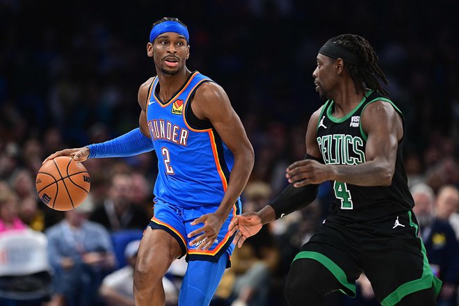 Shai Gilgeous-Alexander (z žogo) je bil prvo ime derbija večera v ligi NBA. FOTO: Joshua Gateley/AFP