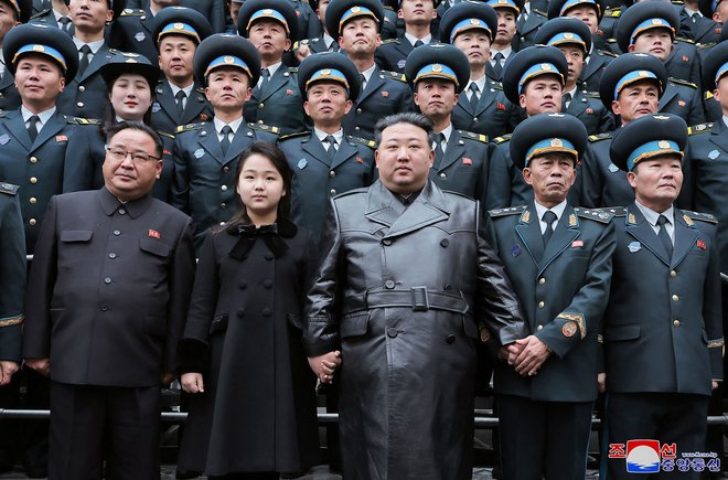 Kim Jong Un s hčerko Džu Ae in skupino znanstvenikov, zaslužnih za izstrelitev izvidniškega satelita, novembra lani v Nacionalnem direktoratu za vesoljsko tehnologijo v Pjongjangu FOTO: KCNA via KNS/AFP