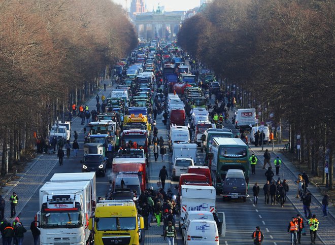 Kmetje so se s traktorji, tovornimi vozili in drugimi prevoznimi sredstvi v dolgih kolonah odpravili pred Brandenburška vrata v Berlinu. FOTO: Nadja Wohlleben/Reuters