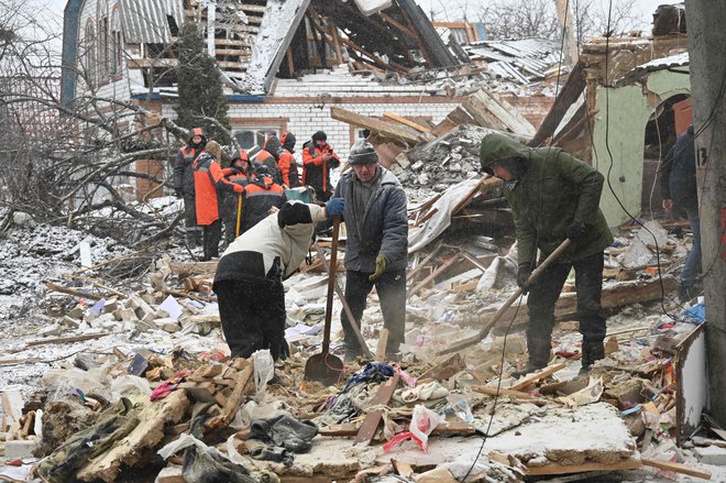 Reševalci in prebivalci mesta Zmijiv v Harkovski oblasti se spoprijemajo s posledicami jutranjega ponovnega množičnega ruskega raketnega napada na Ukrajino. FOTO: Sergej Bobok/AFP