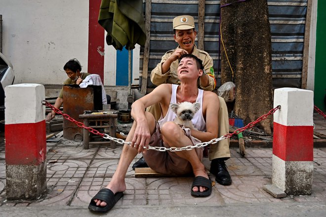 Na ulici v Hanoju moški odstrani sive lase svojemu prijatelju. Foto: Nhac NguyenfAfp