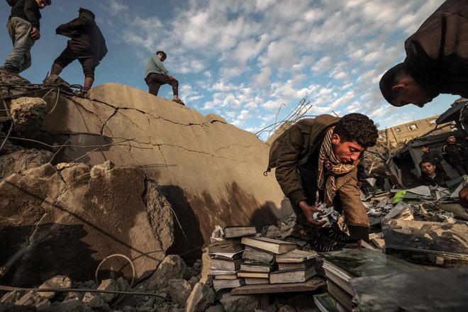 Palestinska mladina zbira knjige iz ruševin mošeje in stavb, ki so se podrle med izraelskim bombardiranjem mesta Rafa na jugu Gaze med nenehnimi spopadi med Izraelom in palestinsko militantno skupino Hamas. Foto: Afp