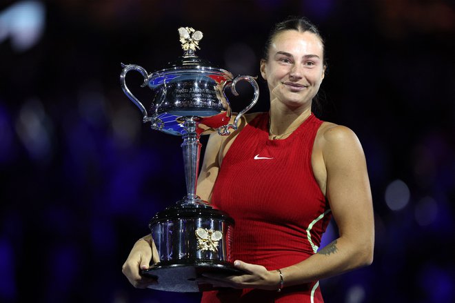 Arina Sabalenka je ponosno pokazala lovoriko za velik podvig. FOTO: Martin Keep/AFP