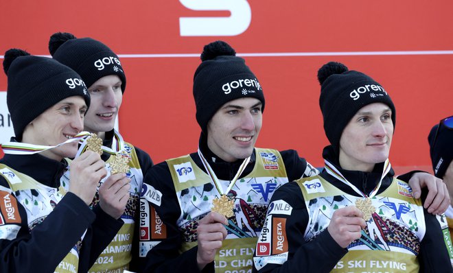 Peter Prevc, Lovro Kos, Timi Zajc in Domen Prevc (z leve) z zasluženimi zlatimi kolajnami. FOTO: Leonhard Föger/Reuters