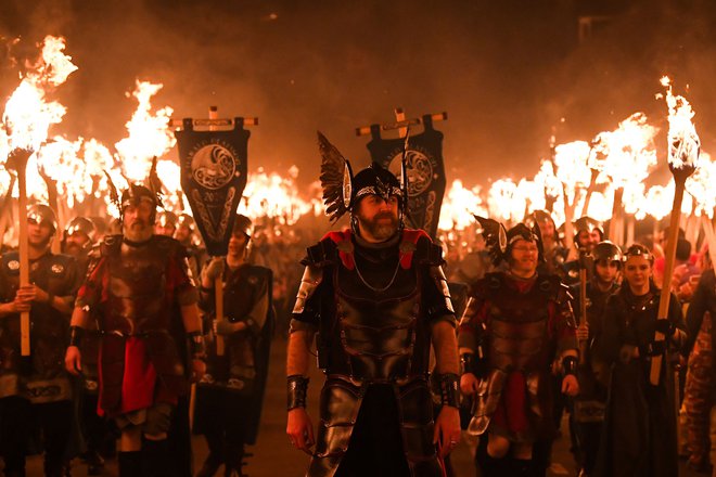 Člani skupine »Jarl Squad« paradirajo po ulicah mesta Lerwick na Šetlandskih otokih med festivalom Up Helly Aa. Up Helly Aa praznuje vpliv skandinavskih Vikingov na Shetlandskih otokih, vrhunec pa doseže z do 1000 moškimi v kostumih, ki zvečer v vikinško ladjo vržejo goreče bakle in jo zažgejo. Foto: Andy Buchanan/Afp