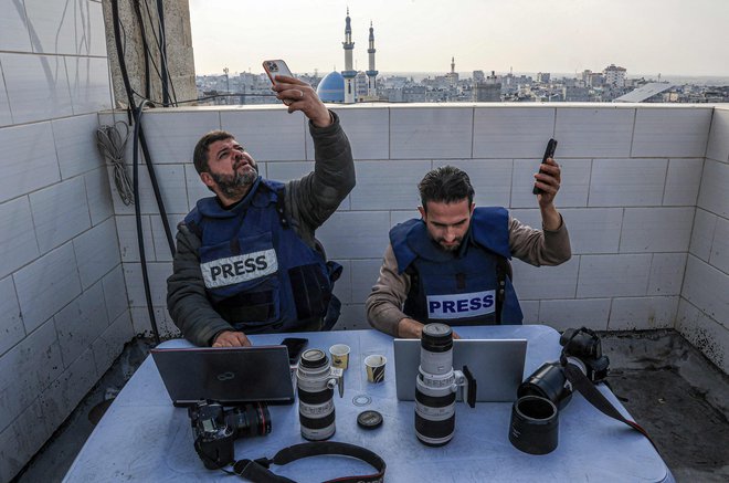 V Rafi na jugu Gaze se palestinski novinarji poskušajo povezati z internetom. Izpadi električne energije so v razdejani Gazi postali vsakdanjost. Vendar lahko Palestinci z vgrajenimi karticami SIM še vedno dostopajo do interneta in ostanejo v stiku s svojimi bližnjimi v tujini. Foto: Said Khatib/Afp