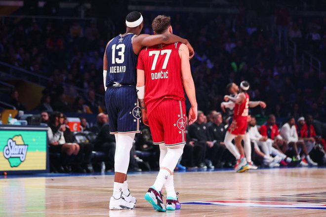 Prizor, ki pove marsikaj o tekmovalnosti med letošnjim dvobojem vseh zvezd: Luka Dončić in Bam Adebayo objeta spremljata dogajanje na parketu. FOTO: Stacy Revere/AFP