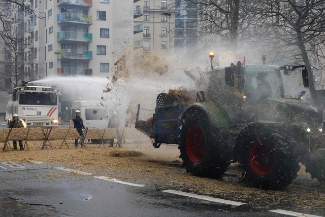 Med zasedanjem kmetijskih ministrov EU v palači Evropa so evropsko četrt v Bruslju oblegali kmetje s skoraj tisoč traktorji. FOTO: Nicolas Maeterlinck/AFP
