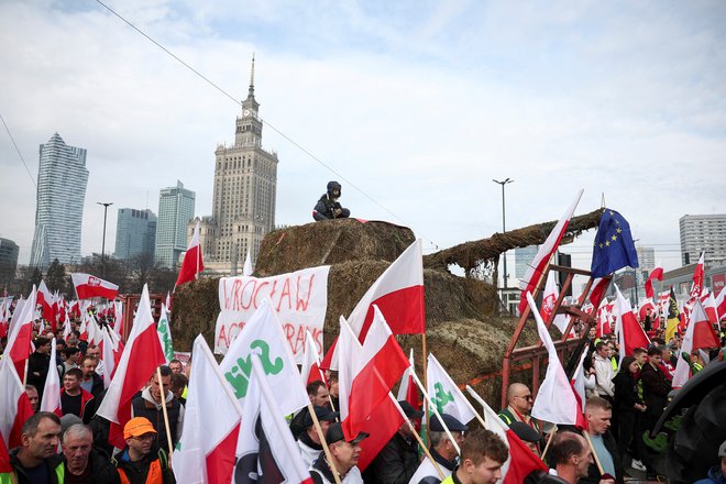 Protestniki v Varšavi s tankom, izdelanim iz senenih bal. FOTO: Kacper Pempel/Reuters