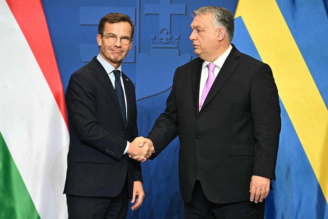 Švedski predsednik vlade Ulf Kristersson (levo) in njegov madžarski gostitelj Viktor Orbán sta prejšnji petek v Budimpešti priredila tiskovno konferenco, na kateri je madžarski premier povedal, da sta državi zdaj »pripravljeni umreti druga za drugo«. FOTO: Attila Kisbenedek/AFP