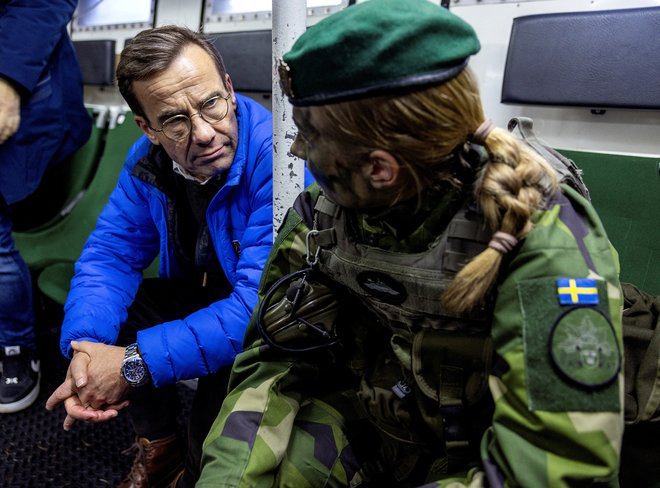 Švedski premier Ulf Kristersson na bojni ladji švedske mornarice med pogovorom z vojakinjo po predstavitvi novega svežnja vojaške pomoči, ki ga je nova članica Nato zveze pripravila za napadeno državo. Foto: Tt News Agency Via Reuters