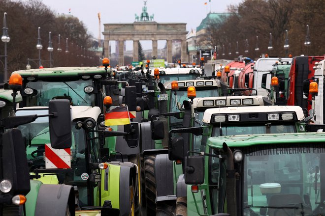 Kmetje so med protesti že večkrat blokirali ceste okoli Brandenburških vrat v Berlinu FOTO: Christian Mang/REUTERS