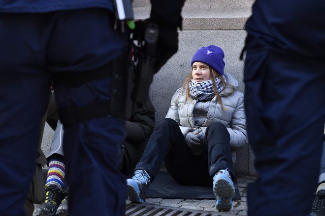 Danes zjutraj sta dva policista »na silo« dvignila podnebno aktivistko Greto Thunberg in jo odnesla stran od vrat švedskega parlamenta. FOTO: Samuel Steen/AFP