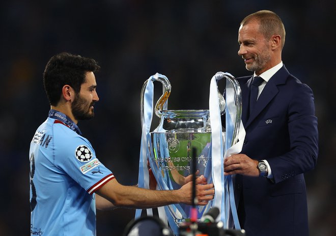 Lanski finale lige prvakov je pripadel Manchester Cityju, takole je predsednik Uefe Aleksander Čeferin izročil prestižni pokal kapetanu kluba Ilkayu Gündoganu. FOTO: Molly Darlington/Reuters