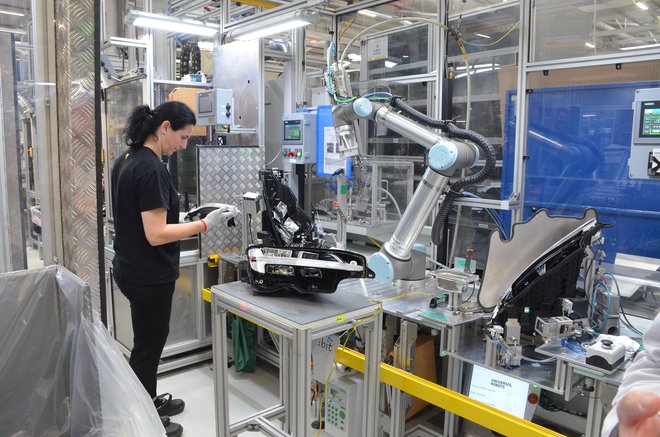 Proizvodnja žarometa, pri kateri operater sodeluje s tako imenovanim kolaborativnim robotom. FOTO: Gašper Boncelj