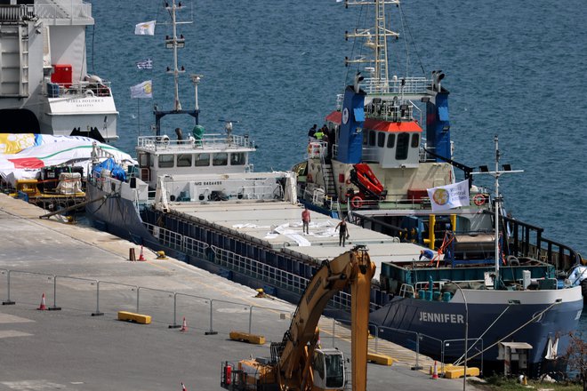 Člani posadke delajo na tovorni ladji, natovorjeni s humanitarno pomočjo za Gazo FOTO: Yiannis Kourtoglou/Reuters