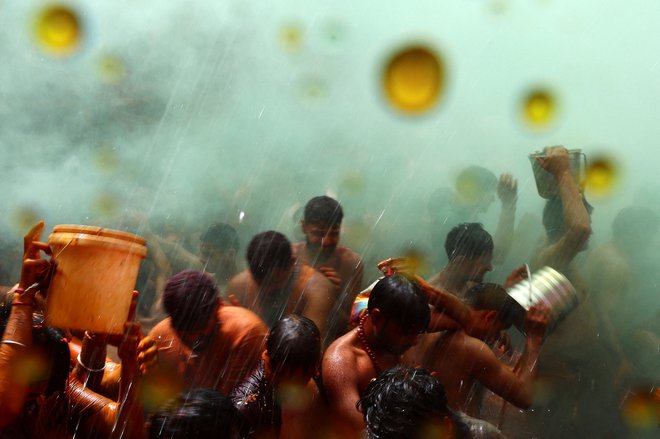 Hindujski verniki sodelujejo v igri huranga, ki jo moški in ženske igrajo dan po Holiju, v templju Daujii v bližini mesta Mathura na severu Indije. Foto: Sharafat Ali/Reuters