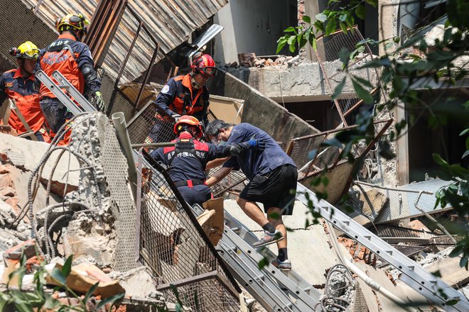 Reševalci pomagajo preživelim izpod ruševin. Več deset ljudi ostaja ujetih. FOTO: AFP