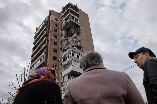 Prebivalci Harkova red eno od poškodovanih stavb. FOTO: Stringer Reuters