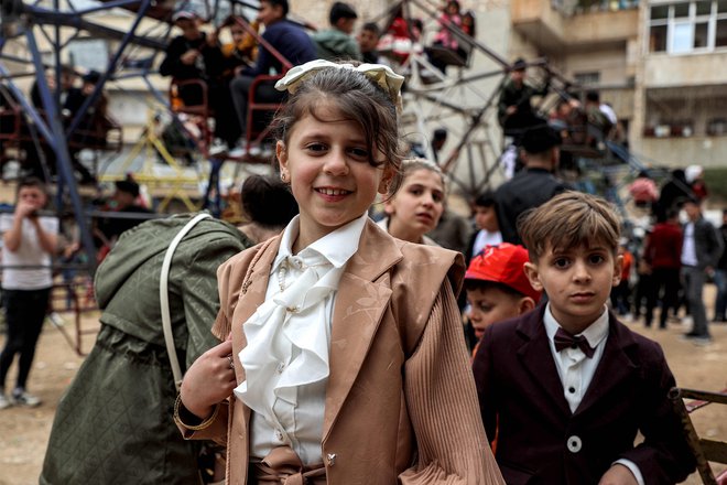 Otroci, oblečeni v nova oblačila čakajo na veselo vožnjo v mestu Ariha v sirski uporniški severozahodni provinci Idlib, na prvi dan muslimanskega praznika Eid al-Fitr, ki se zaključi s svetim mesecem ramadan. Foto: Aaref Watad/Afp
