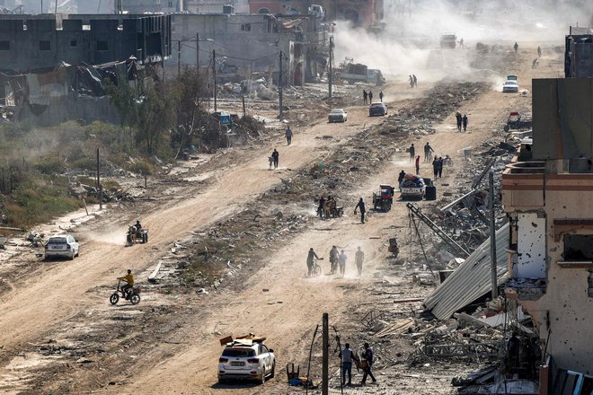 Palestinci hodijo mimo uničenih stavb v Han Junisu na jugu Gaze FOTO: AFP