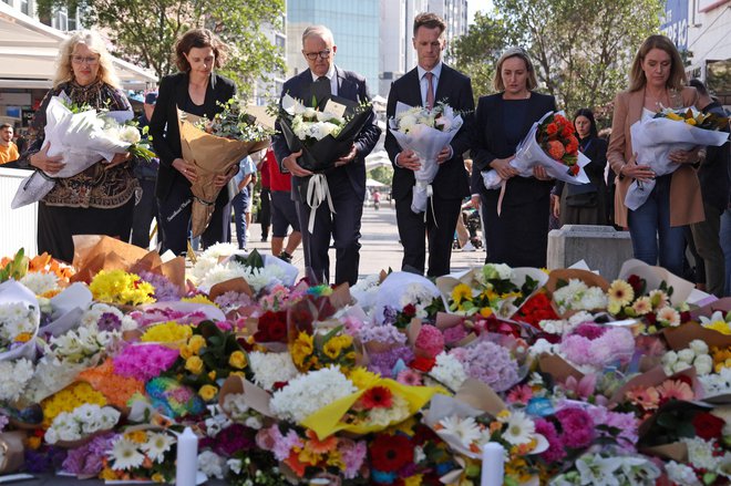 Pred nakupovalnim središčem Bondi je ogromno rož, s katerimi so se ljudje poklonili žrtvam napada. Na fotografiji (v sredini) avstralski premier Anthony Albanese. FOTO: David Gray/AFP