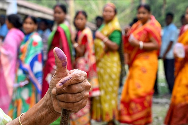 Indijka kaže s črnilom zaznamovani prst, potem ko je oddala svoj glas na prvi fazi splošnih volitev na volišču v vasi Kalamati. Do 1. junija bo sedem volilnih dni, ko bodo volitve potekale v različnih indijskih zveznih državah. Izid volitev naj bi bil znan 4. junija. Foto: Dibyangshu Sarkar/Afp