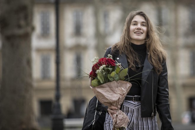Ženska s šopkom rož na ulici Ljubljane marca leta 2019. Fotografija je simbolična. FOTO: Voranc Vogel/Delo
