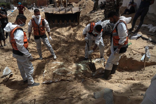 V zadnjih petih dneh so pripadniki palestinske civilne zaščite, ki jim pomagajo forenziki, iz množičnega grobišča odkopali 324 trupel, ki so bila pred bolnišnico Naser prekrita z zemljo, ruševinami in smetmi. FOTO: AFP