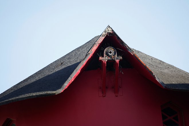 Pogled na znameniti rdeči mlin na veter na vrhu Moulin Rougea, najbolj znanega pariškega kabareta, potem ko mu je ponoči odpadla vetrnica. FOTO: Benoit Tessier/Reuters