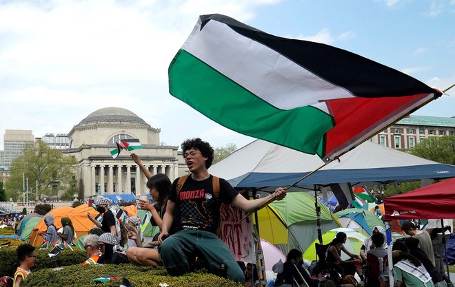 Študenti zasedajo propalestinski tabor »Gaza Solidarity Encampment« na zelenici Univerze Columbia v New Yorku. Na Univerzi Columbia, ki je epicenter vala propalestinskih protestov po ameriških kampusih, so se včeraj povečale napetosti, saj so oblasti napovedale prekinitev pogovorov s študenti in pozvale k odstranitvi njihovega tabora z območja univerze. Foto: Timothy A. Clary/Afp