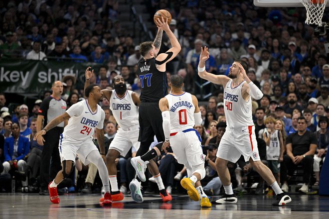 Dončić se je v raketi pogosto znašel obkrožen s štirimi branilci, kar je odlično izkoristil s 13 asistencami. Foto Jerome Miron/Reuters