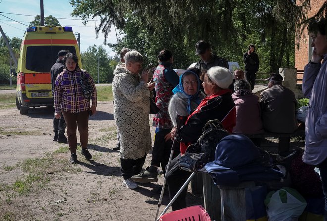 Prebivalci mesta Vovčansk in okoliških vasi čakajo na avtobuse za evakuacijo v Harkov. FOTO: Vyacheslav Madiyevskyy/Reuters