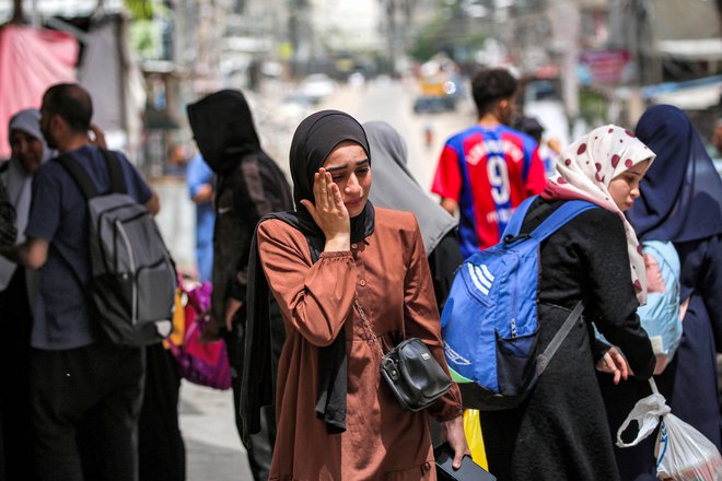 Obupana ženska čaka na evakuacijo iz Rafe. FOTO: AFP