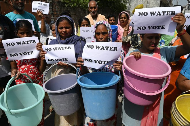 Prebivalci v Amritsarju držijo plakate z napisom »Brez vode ni volilnega glasu« in vedra, s katerimi protestirajo zaradi neustrezne oskrbe z vodo. V odročni indijski vasi v Himalaji so odprli volišče za edino tam živečo petčlansko družino. Volilni uradniki so do vasi potovali sedem ur. V Indiji, ki ima skoraj milijardo volilnih upravičencev, ki glasujejo na več kot milijonu volišč, parlamentarne volitve potekajo v sedmih fazah. Začele so se 19. aprila, potekale pa bodo do 1. junija. Foto: Narinder Nanu/Afp