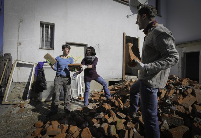 Prostovoljci pomagajo urejati hišo. FOTO: Jože Suhadolnik/Delo