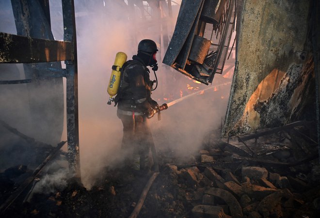 Ukrajinski gasilec v eni od porušenih stavb v Harkovu. FOTO: Sergey Bobok/Afp
