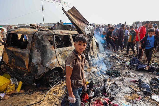 Izraelske rakete so namreč zadele veliko šotorsko naselje, ki se nahaja ob skladišču Agencije Združenih narodov za pomoč palestinskim beguncem. Foto Eyad Baba/AFP