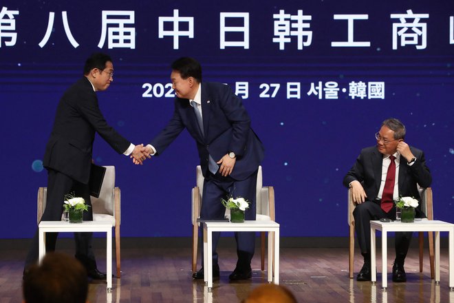 Na srečanju Li Qianga (desno) z južnokorejskim predsednikom Jun Sok Jolom (v sredini) in japonskim premierom Fumiem Kišido je bila glavna tema trgovinsko in tehnološko sodelovanje. FOTO: Chung Sung-jun/AFP