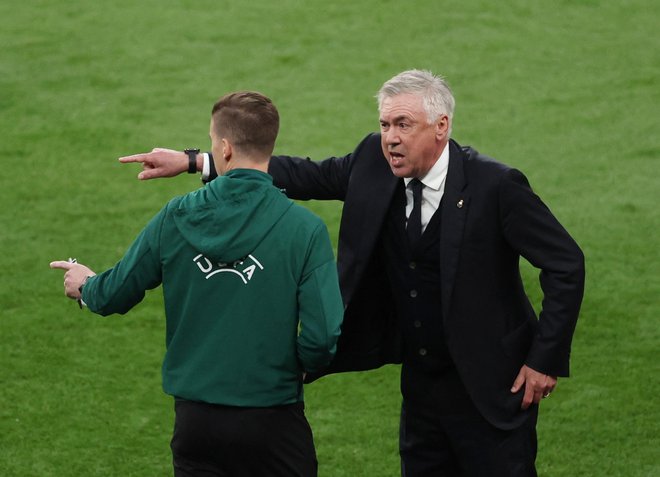 Realov trener Carlo Ancelotti z enim od sodnikov. FOTO: Claudia Greco/Reuters