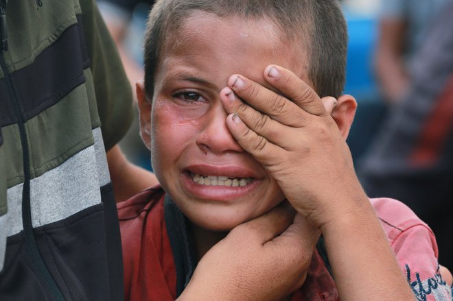 Palestinski deček joka zaradi smrti svojega očeta, ki je bil ponoči ubit v izraelskem zračnem napadu pred bolnišnico mučencev Al-Aksa v Deir al-Balahu. Izrael kljub obnovljenim prizadevanjem za prekinitev ognja v Gazi nadaljuje napade na palestinsko enklavo. Ponoči so izraelske sile ubile najmanj 22 ljudi, napadle pa so tudi ozemlje Sirije. Foto: Bashar Taleb/Afp