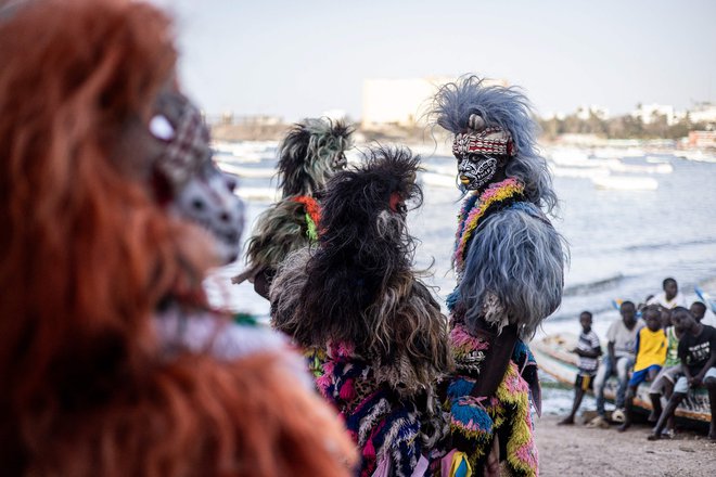Nastopajoči v tradicionalnih kostumih nastopajo na znamenitem šovu lažnih levov na kulturnem dogodku na plaži Ngor v Dakarju. Foto: John Wessels/Afp