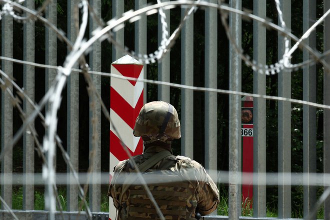 Vojak ob ograji na poljsko-beloruski meji. FOTO: Kacper Pempel/Reuters