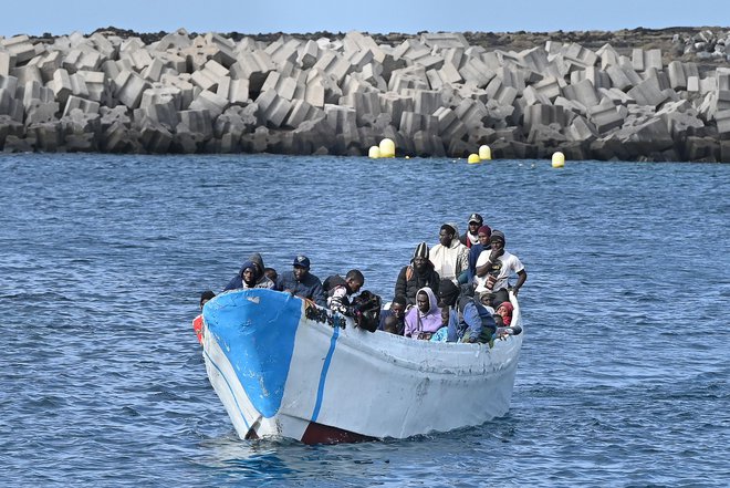 TOPSHOT - Migrants sit in a boat, after the Spanish Salvamento Maritimo (Sea Search and Rescue agency) vessel "Salvamar Adhara" rescued around 250 migrants in three different boats at sea, at La Restinga port, in the municipality of El Pinar on the Canary Island of El Hierro, on February 4, 2023. (Photo by STRINGER/AFP) Foto Stringer Afp