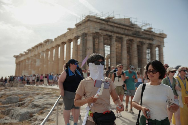 Najbolj obiskano turistično znamenitost v Grčiji, atensko Akropolo, so zaradi visokih temperatur v sredo in v četrtek zaprli za obiskovalce. Podobno odločitev so pristojne oblasti večkrat sprejele že lani. FOTO: Louiza Vradi/Reuters