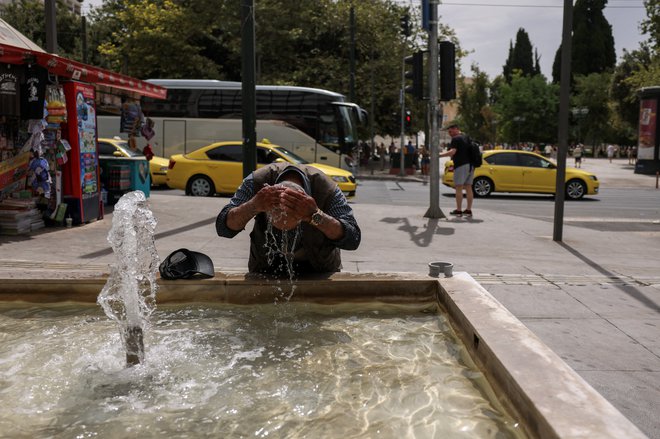 Prostovoljci Rdečega križa so razdelili na tisoče brezplačnih steklenic vode, atenska mestna hiša pa je postavila hladilne postaje. FOTO: Stelios Misinas/Reuters