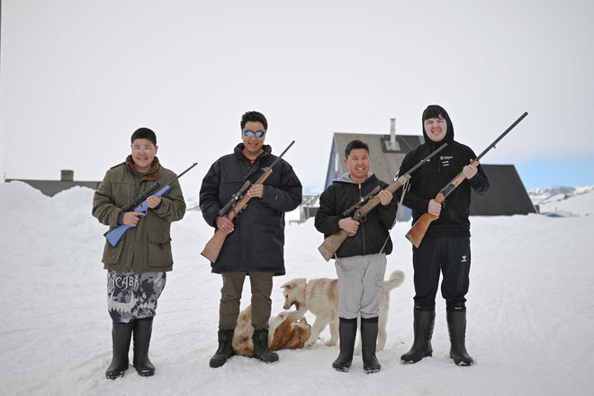 Pprtret Petra Hammekena in njegovih sinov v kraju Ittoqqortoormiit blizu zamrznjenega fjorda Scoresbysund. Vas Ittoqqortoormitt s pisanimi hišami in 350 prebivalci leži v bližini ožine Scoresby, največjega fjorda na svetu, na vzhodni obali Grenlandije, na robu Arktike. Vsi moški so lovci - medvedi, če so profesionalci, tjulnji, narvali ali pižmovke, če so amaterji. To je način življenja prednikov, ki se prenaša iz roda v rod. Toda v zadnjih dvajsetih letih so podnebne spremembe in kvote postopoma ogrozile tradicijo, ki zagotavlja preživetje inuitskih družin. Foto: Olivier Morin/Afp

 