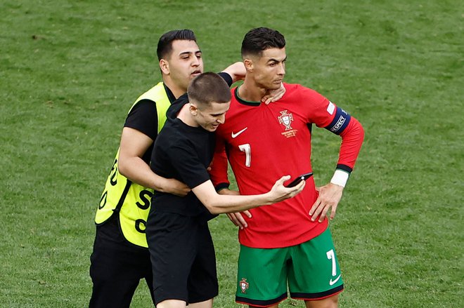 Na tekmi med Portugalsko in Turčijo je na igrišče prišel nepovabljen gost in posnel selfi s Cristianom Ronaldom. FOTO: Kenzo Tribouillard/AFP